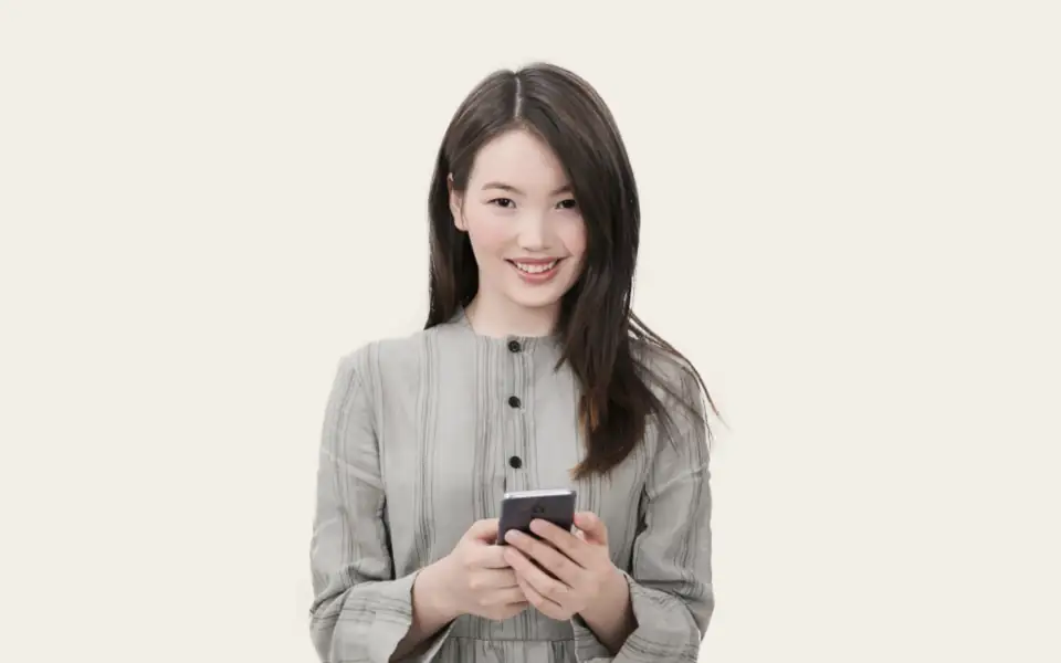 Smiling woman using her smartphone to log in to a JLBETPH account