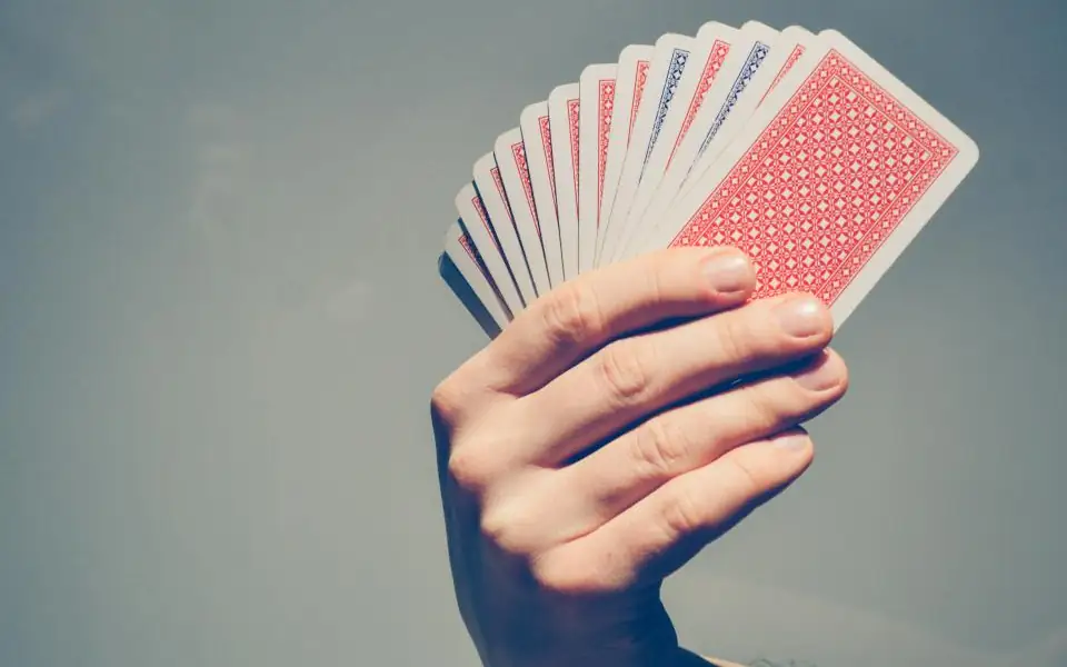 Hand fanning a deck of playing cards for a JLBETPH poker session