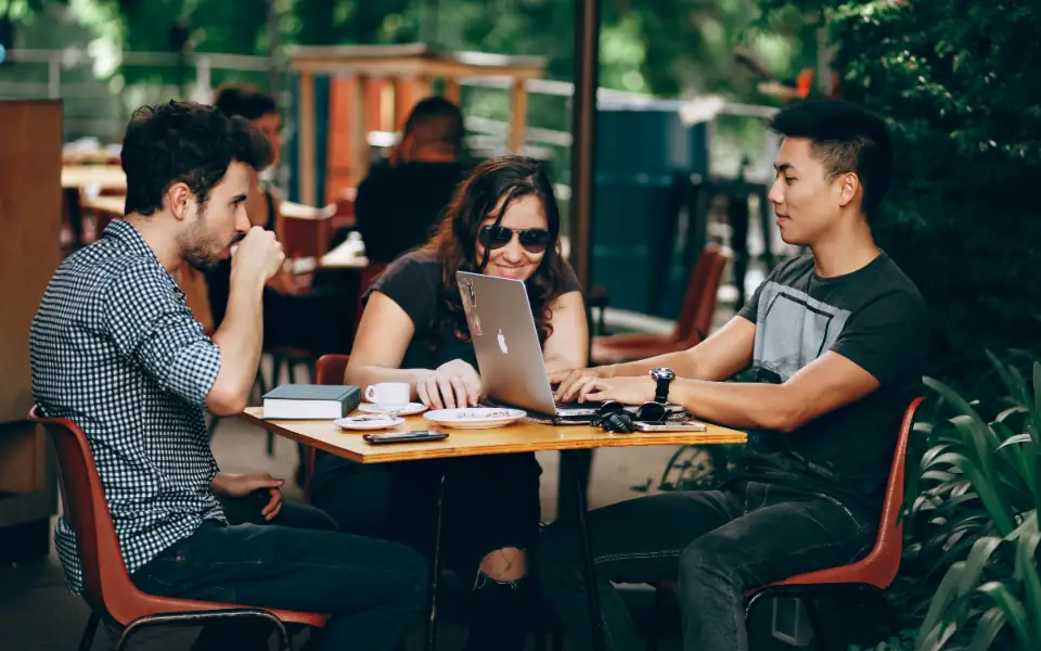 The JLBETPH research team reviewing casino sites on a laptop at a cafe table